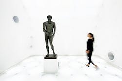 FIG. 1. Planar lighting behind a textile surface delivers an almost dimensionless space where visitors see the Greek athlete Apoxyomenos risen from the seabed, presented with no shadows yet with lighting that reveals the architectural detail of the bronze work. (Photo credit: All photos, Zumtobel/photographer Faruk Pinjo.)