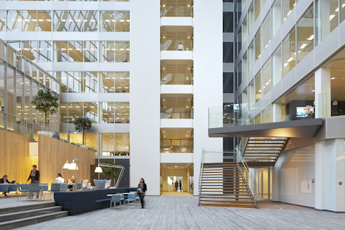 FIG. 1. The newly-built Edge building in Amsterdam is known for its IoT backbone and the ubiquitous deployment of Power over Ethernet as a backbone that enables advanced applications such as space optimization, but building retrofits need the flexibility of a wireless network and a standard intra-luminaire bus can enable flexible choices in inter-luminaire connectivity. (Photo credit: Image courtesy of Deloitte Group, photographer Ronald Tilleman; http://tilleman.nl.)