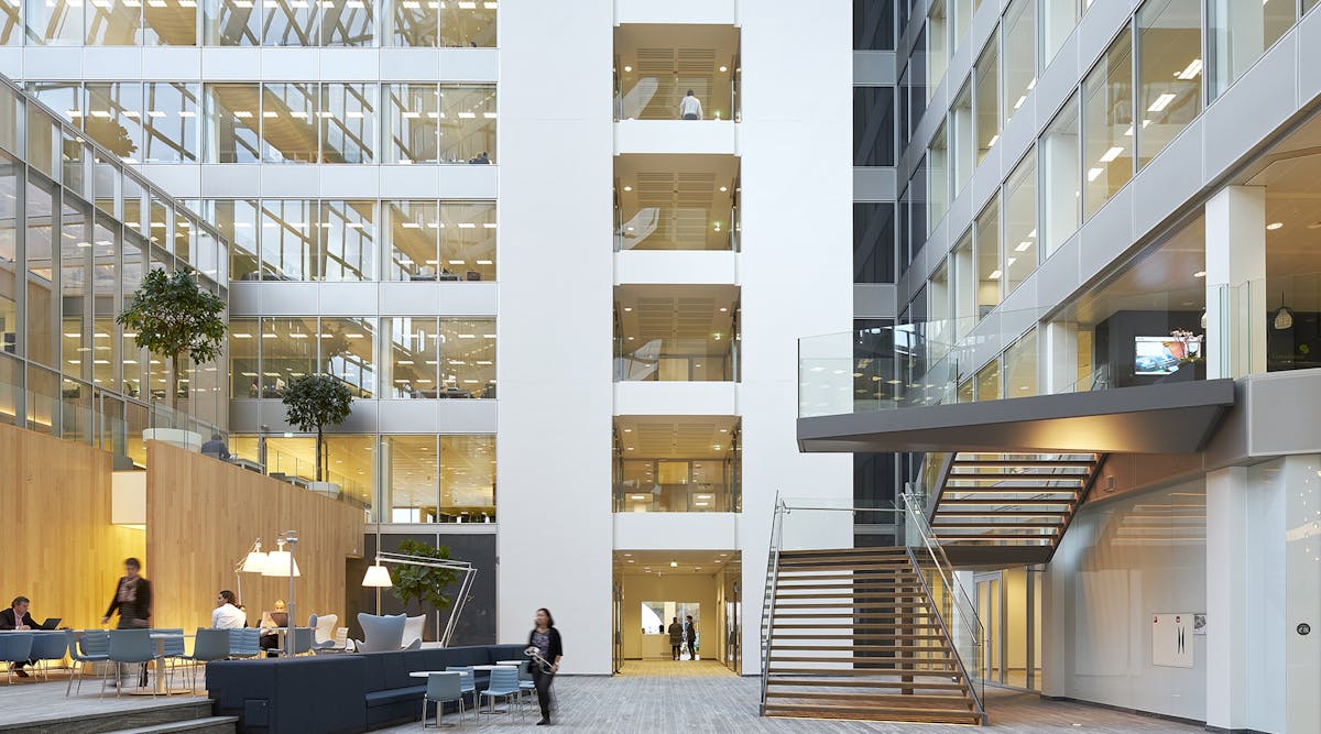 FIG. 1. The newly-built Edge building in Amsterdam is known for its IoT backbone and the ubiquitous deployment of Power over Ethernet as a backbone that enables advanced applications such as space optimization, but building retrofits need the flexibility of a wireless network and a standard intra-luminaire bus can enable flexible choices in inter-luminaire connectivity. (Photo credit: Image courtesy of Deloitte Group, photographer Ronald Tilleman; http://tilleman.nl.)