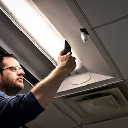 An installer uses a cell phone to configure a connected lighting system in a Next Generation Lighting Systems (NGLS) living lab. [Photo credit: Image courtesy of Pacific Northwest National Laboratory (PNNL) and NGLS.]