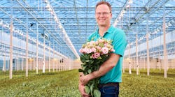 Lisianthus, or Texas bluebell, can be cultivated in many colors. Here Lugt Lisianthus co-owner Marcel Lugt cradles a pink variety under a mix of high-pressure sodium (HPS) and LED luminaires. (Photo credit: Image courtesy of Signify.)