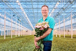 Lisianthus, or Texas bluebell, can be cultivated in many colors. Here Lugt Lisianthus co-owner Marcel Lugt cradles a pink variety under a mix of high-pressure sodium (HPS) and LED luminaires. (Photo credit: Image courtesy of Signify.)