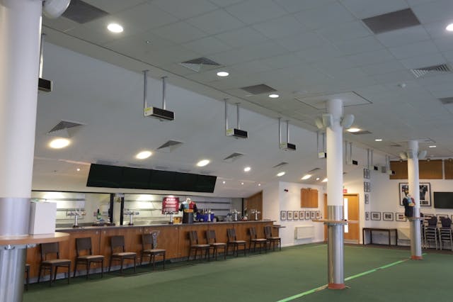 Deeming the usual locker room as dangerous play, Harlequins has outfitted the members&apos; bar with UV-C luminaires such as those hanging from the ceiling in this photo, and has moved the home team in there. (Photo credit: Image courtesy of Signify.)