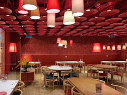 Two of Signify&rsquo;s mercury-vapor-lamp&ndash;based UV-C upper-air cleaners sit atop the red wall at this Thai Town restaurant.