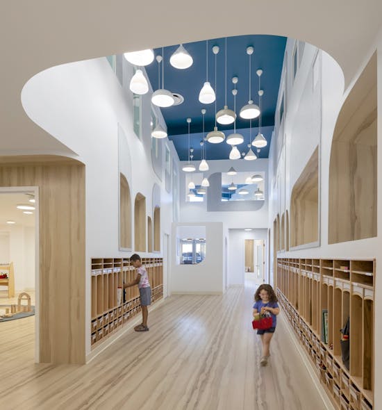 At City Kids, BAAO used pendant fixtures and interior apertures to illuminate the central atrium with electric and indirect natural light.