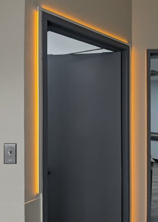 Axis Lighting offers an LED trim light that can wrap doorframes but it must be hardwired.