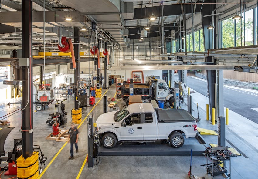 Industrial JEBL High Bays from Lithonia Lighting illuminate the bustling mechanic shop.