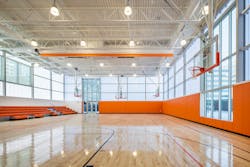 Daylighting and high bays: The gymnasium benefits from natural daylight filtered through frosted acrylic wall coverings and is supplemented by traditional high bays. Daylighting and high bays: The gymnasium benefits from natural daylight filtered through frosted acrylic wall coverings and is supplemented by traditional high bays.