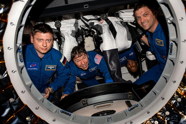 Form left to right: Roscosmos cosmonaut Alexander Grebenkin and NASA astronauts Mike Barratt, Jeanette Epps (upside down), and Matthew Dominick. They will be part-time botanists aboard the ISS for the next six months, using LED lighting. [Image available for use in the public domain - https://www.flickr.com/photos/nasa2explore/53570760432/]